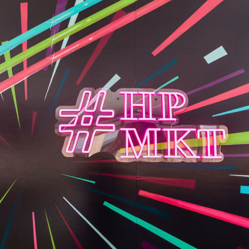 Colorful neon sign that reads '#HPMKT'