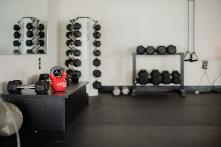 A rack of weights and a kettle bell at Fit Hub