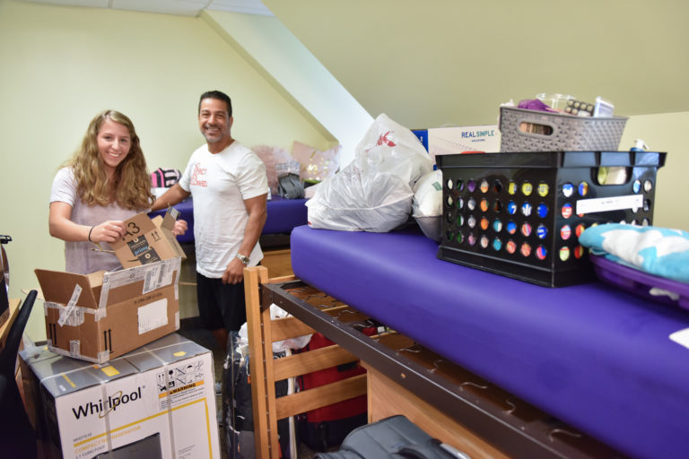 A father helps his daughter unpack for college 