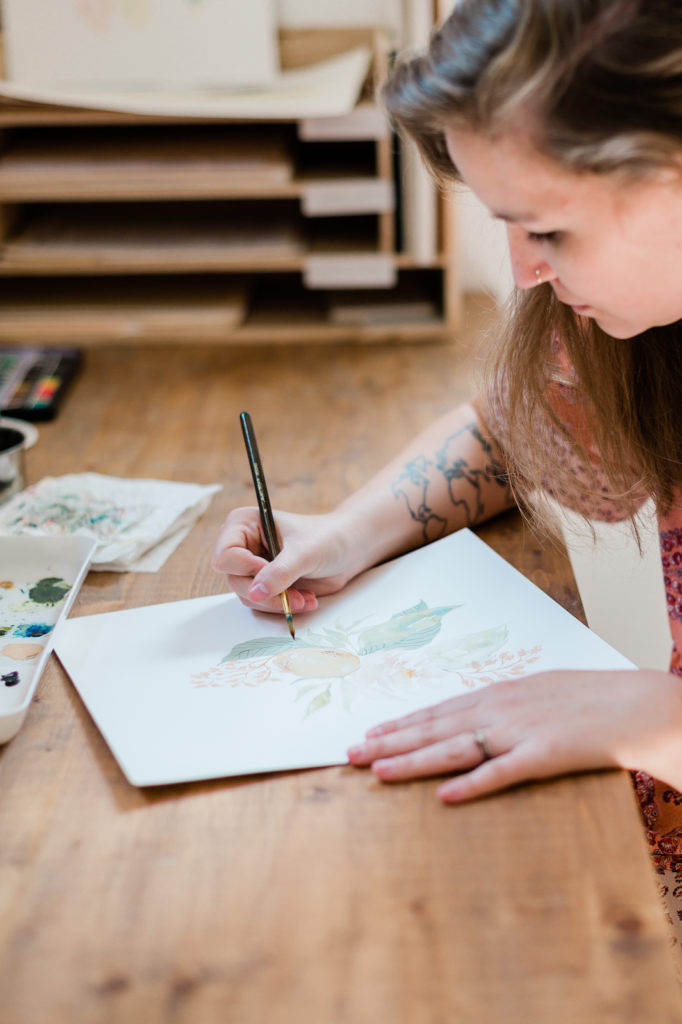 Pen + Paper owner Taylor Mahlke works on a painting for a new notebook. 