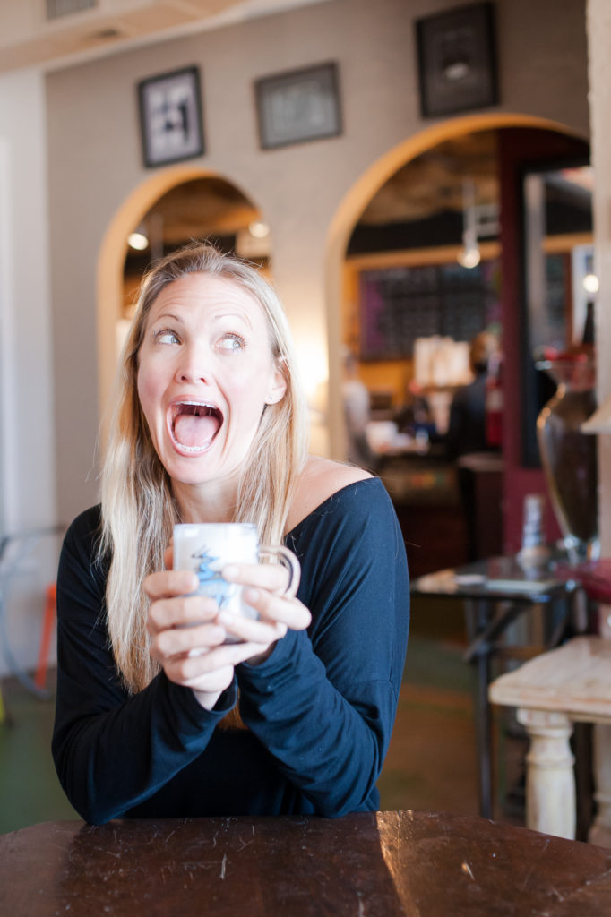 Debeen owner Debbie Maier smiles as she sits and drinks one of her coffee creations. 