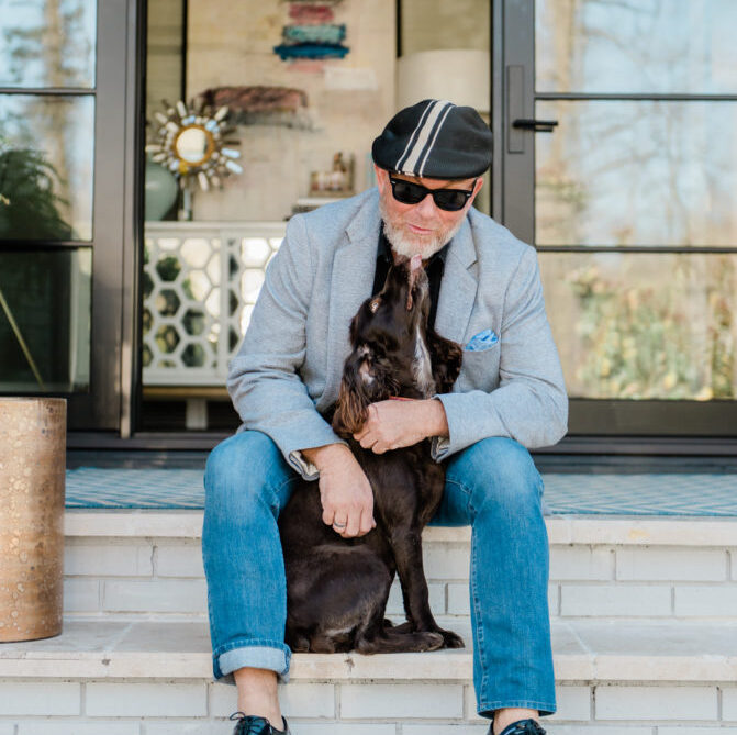 Feature image of Palmer Smith sitting on the front steps of his home with his dog.