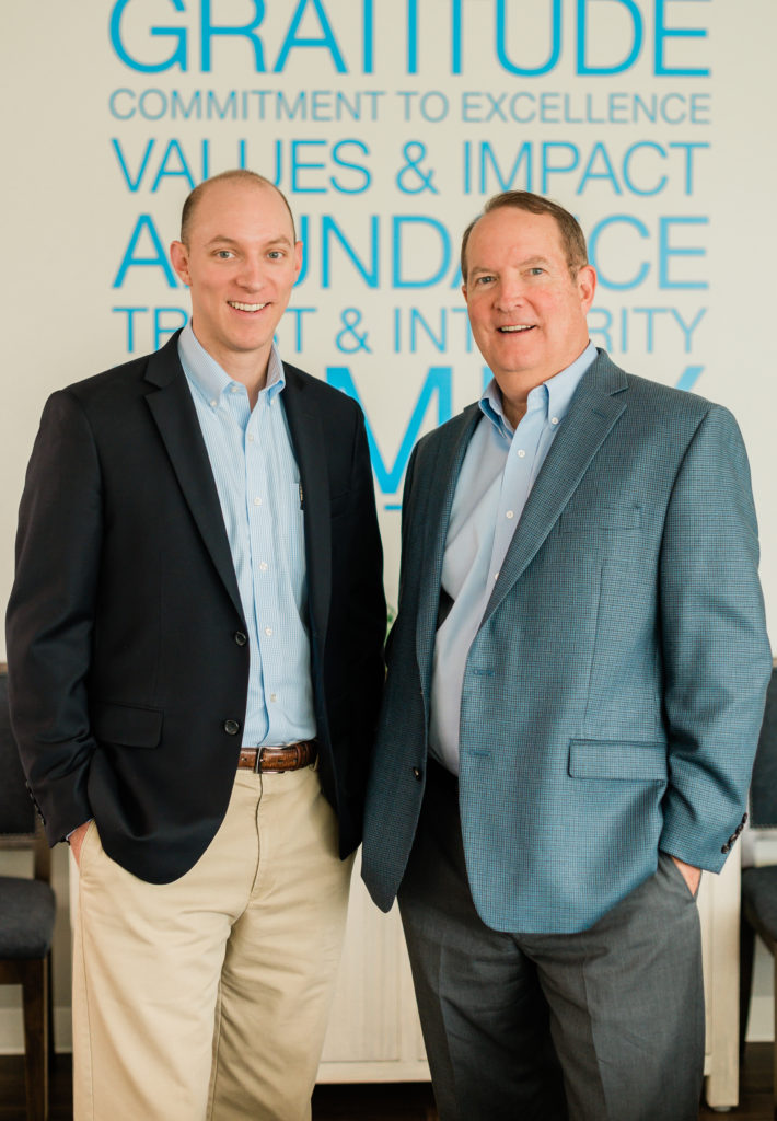 Brad Clinnard, Director of Financial Wellness and his father Ronnie Clinard stand for a photo at Clinard Financial 