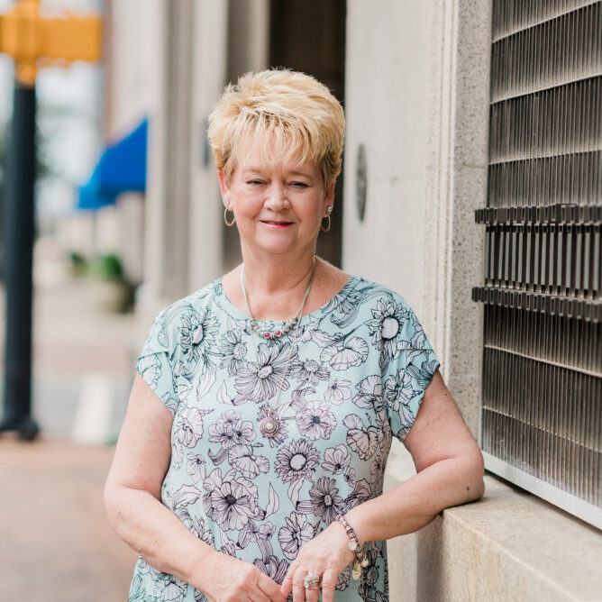 Feature image of Ginger Kerr, Director of Finance & Administration of the High Point Furniture Market Authority standing outside in High Point, NC