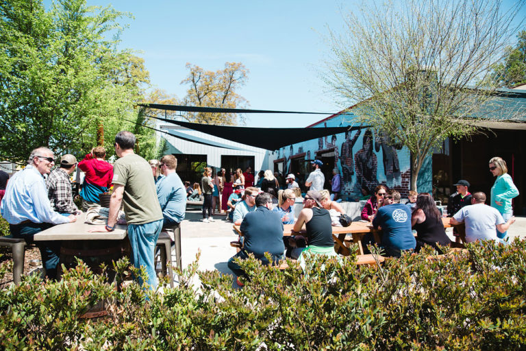 A group of people enjoy themselves on the patio of Brown Truck Brewery