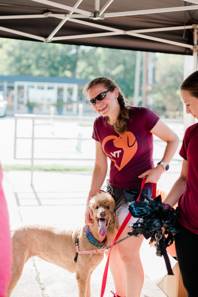 Dr. Rebecca 'Reba' Slivka wears a Virginia Tech vet inspired shirt as she stands with a dog. 