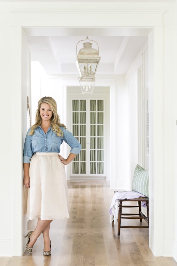 Bria Hammel of Bria Hammel Interior stands for a photo in a white house. 