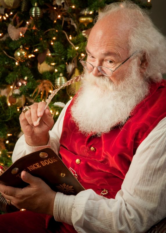 Santa Claus, played by Cliff Snyder, looks at his Christmas list.