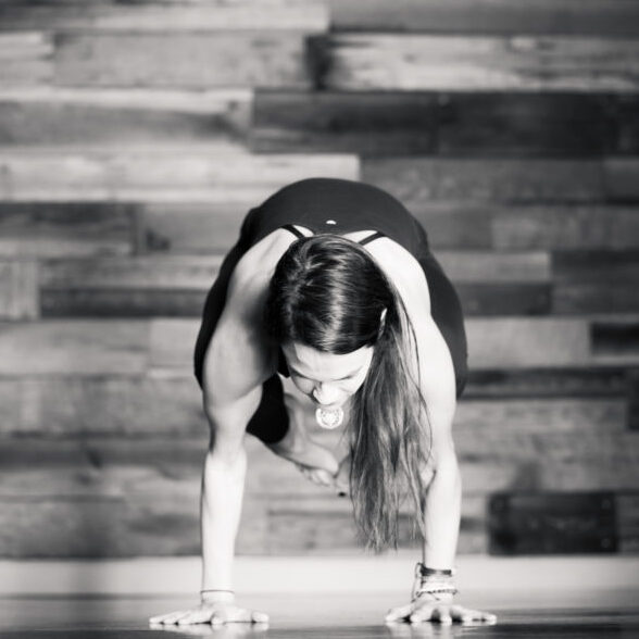 Kelle Yokely of Yoga Mindset in High Point balances on her hands in a yoga pose.