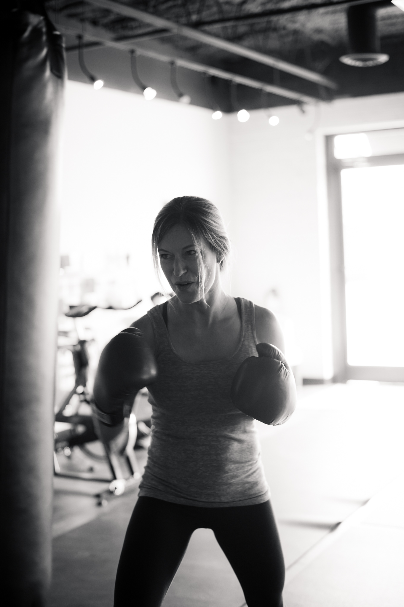 Lori Teppara wears boxing gloves and boxes a punching bag at FIT HUB.