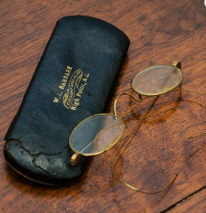 A photo of antique eyeglasses and eyeglasses case.