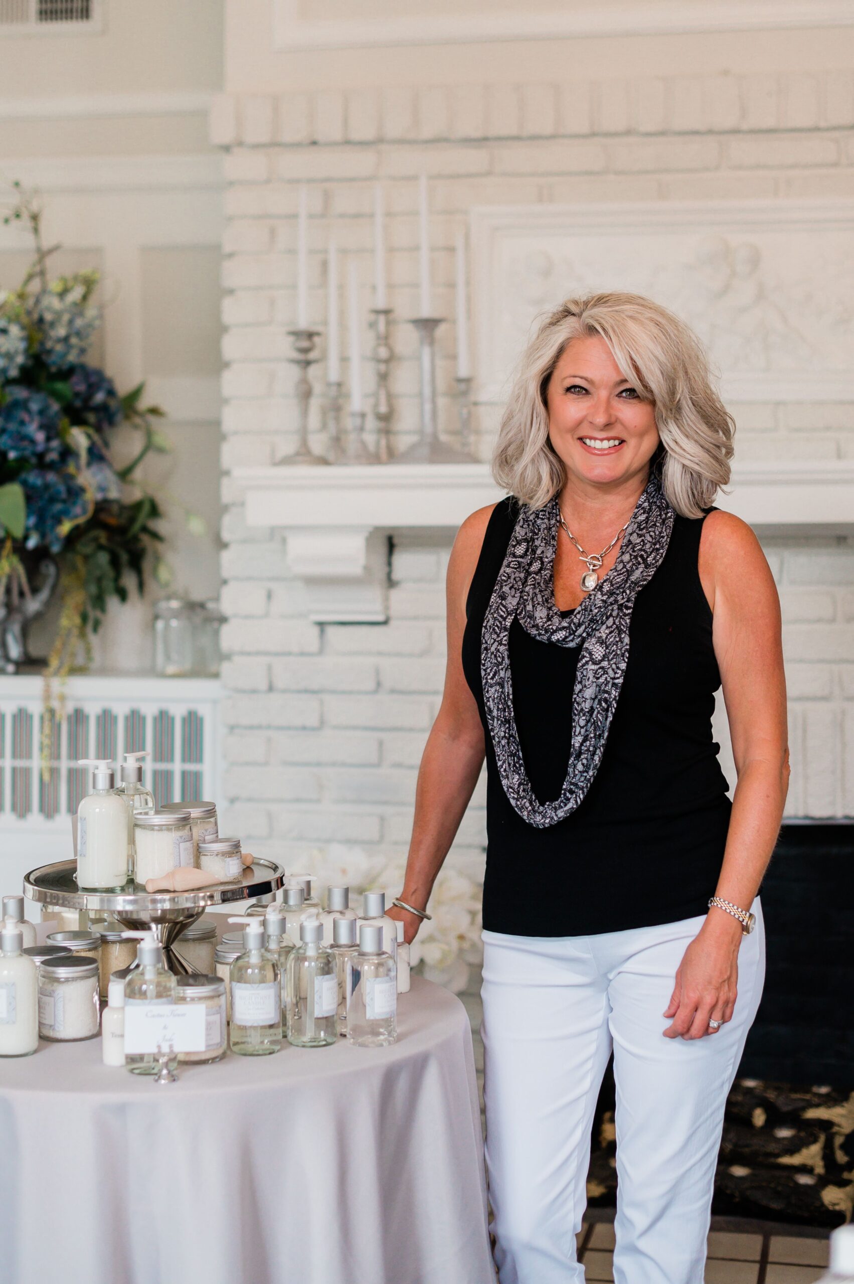 Michelle Shreve-Stroud, owner of High Point Candle stands beside a table of candles in her studio.