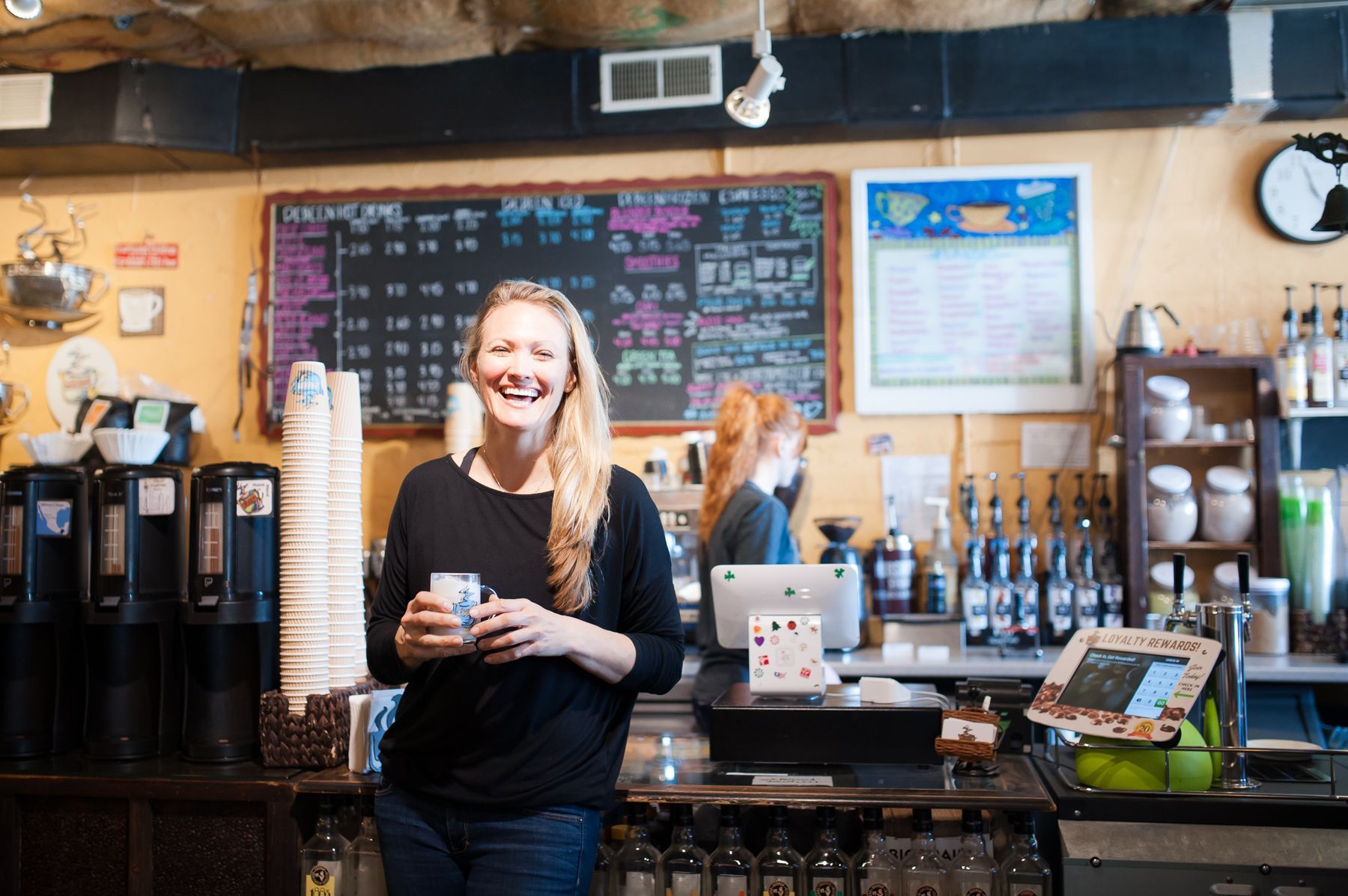 Debbie Maier, owner of DeBeen Espresso, stands with a cup of coffee inside of DeBeen's cafe.