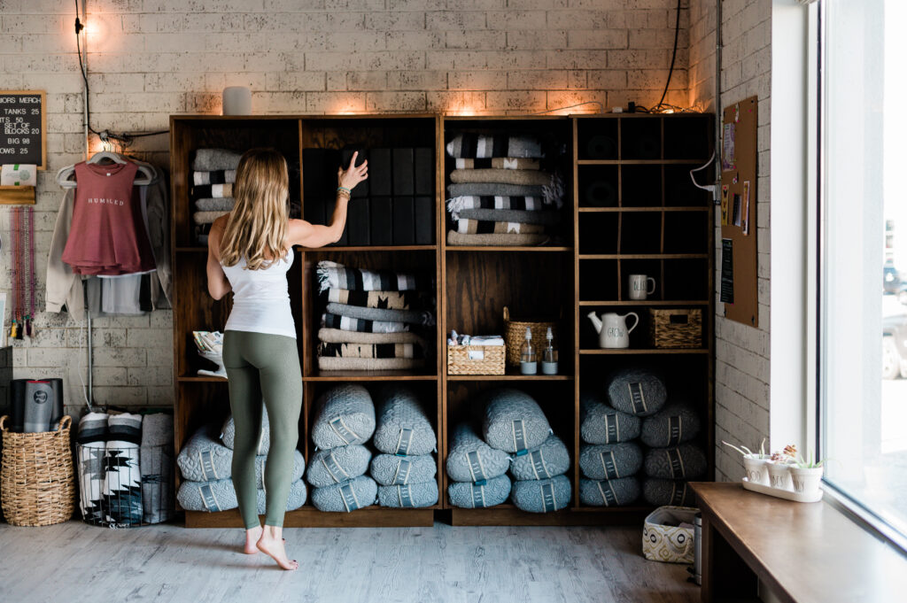 Stacey Field stacks materials in a shelves at Humbled Warriors Yoga.