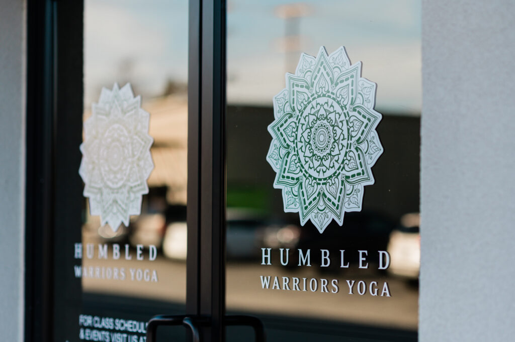 Glass door in the front of Humbled Warriors Yoga with a logo.