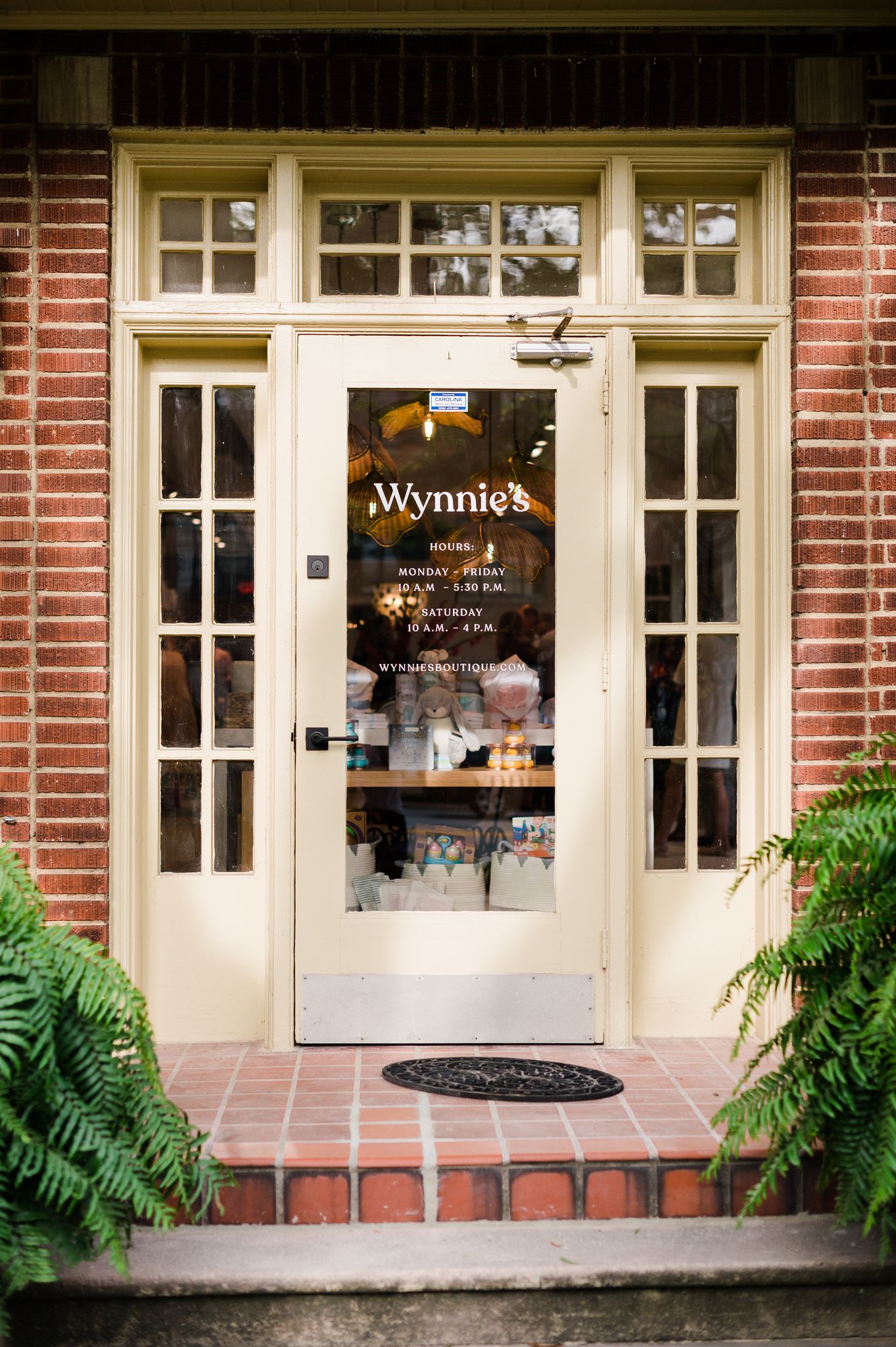 Storefront of a brick building with glass door that says "Wynnie's."