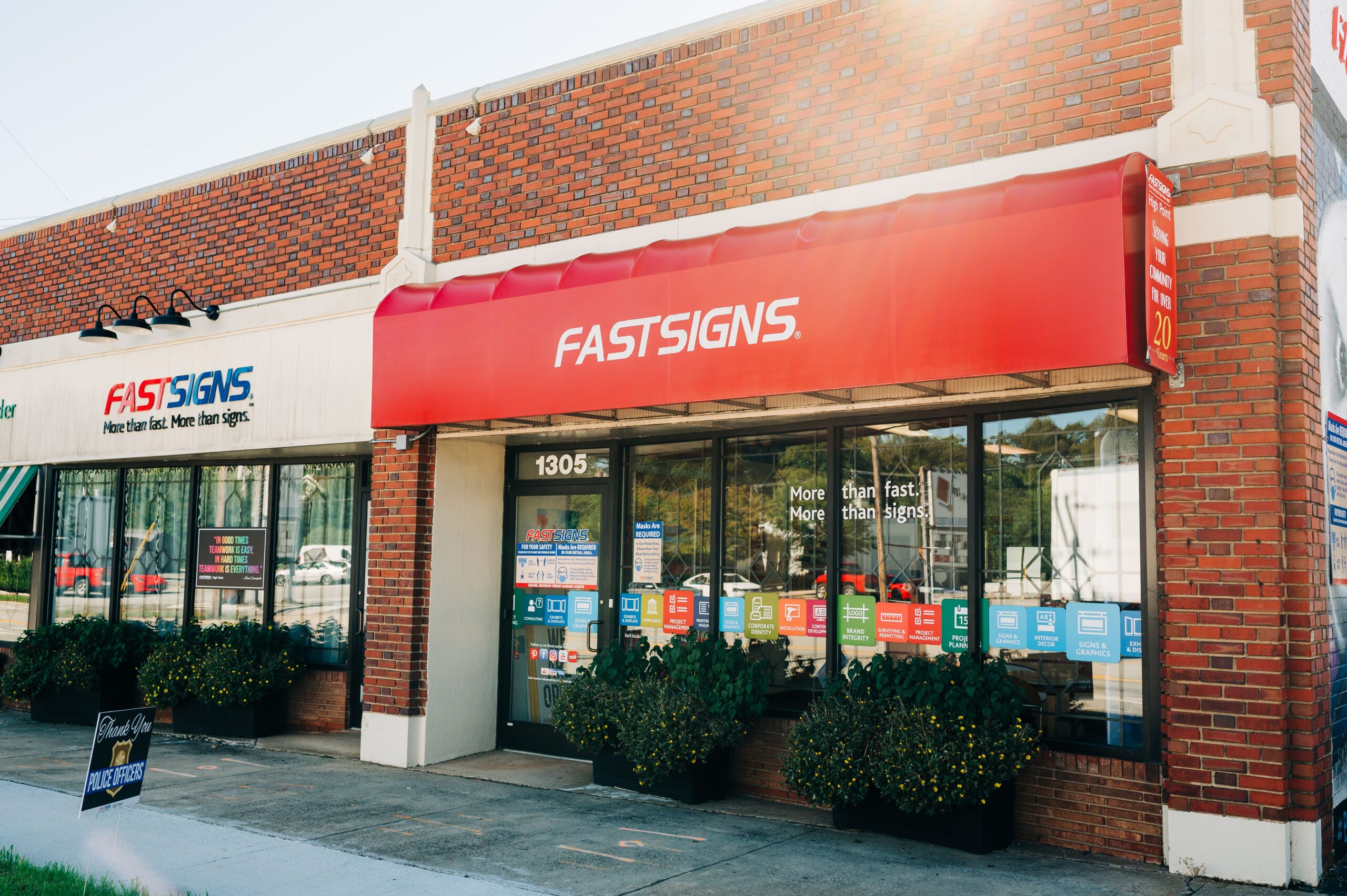 Outdoor shot of a storefront with red awning. In white letters on awning it reads, "Fast Signs." 