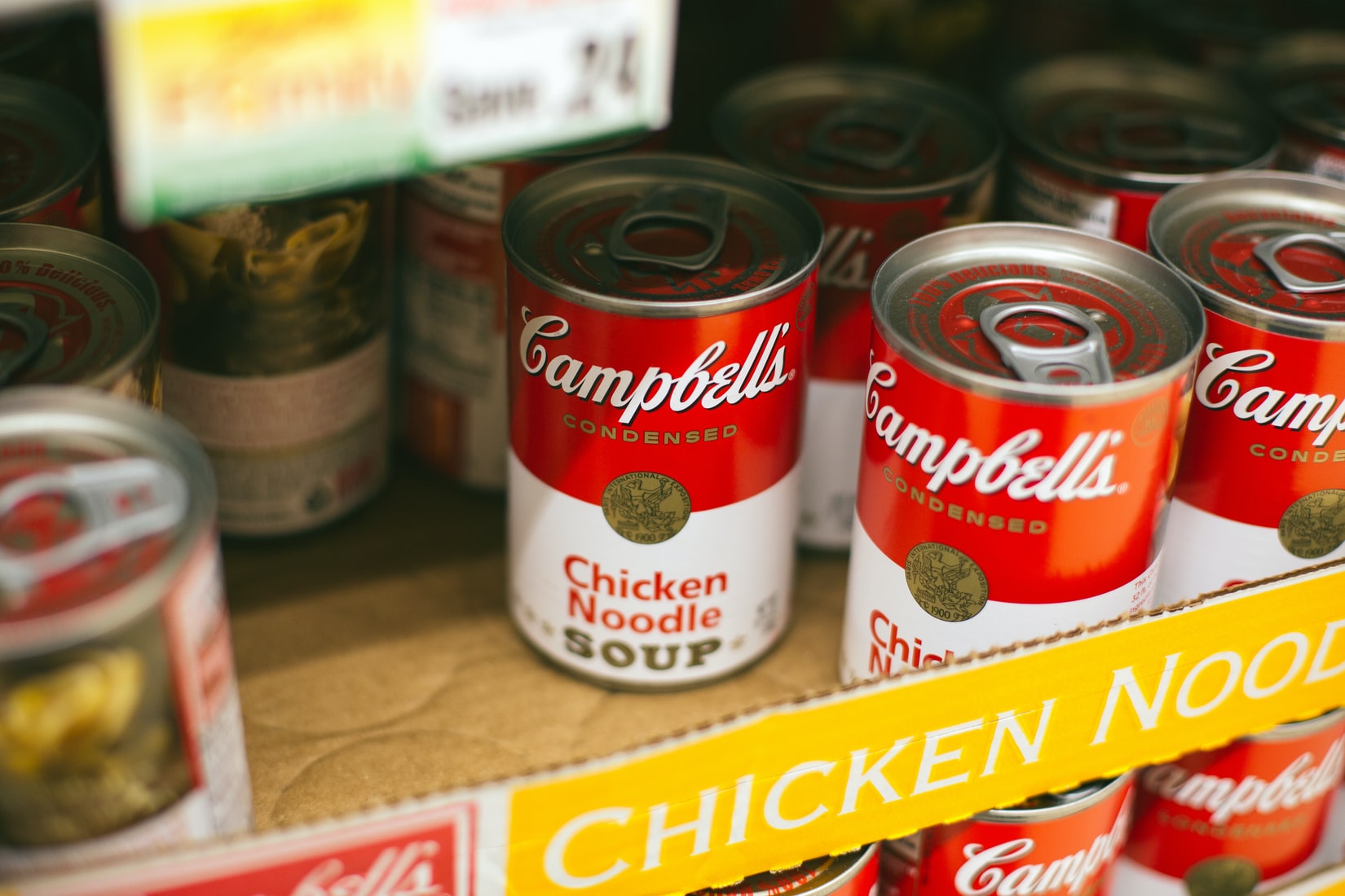 Cans of Campbells Soup in a cardboard box.