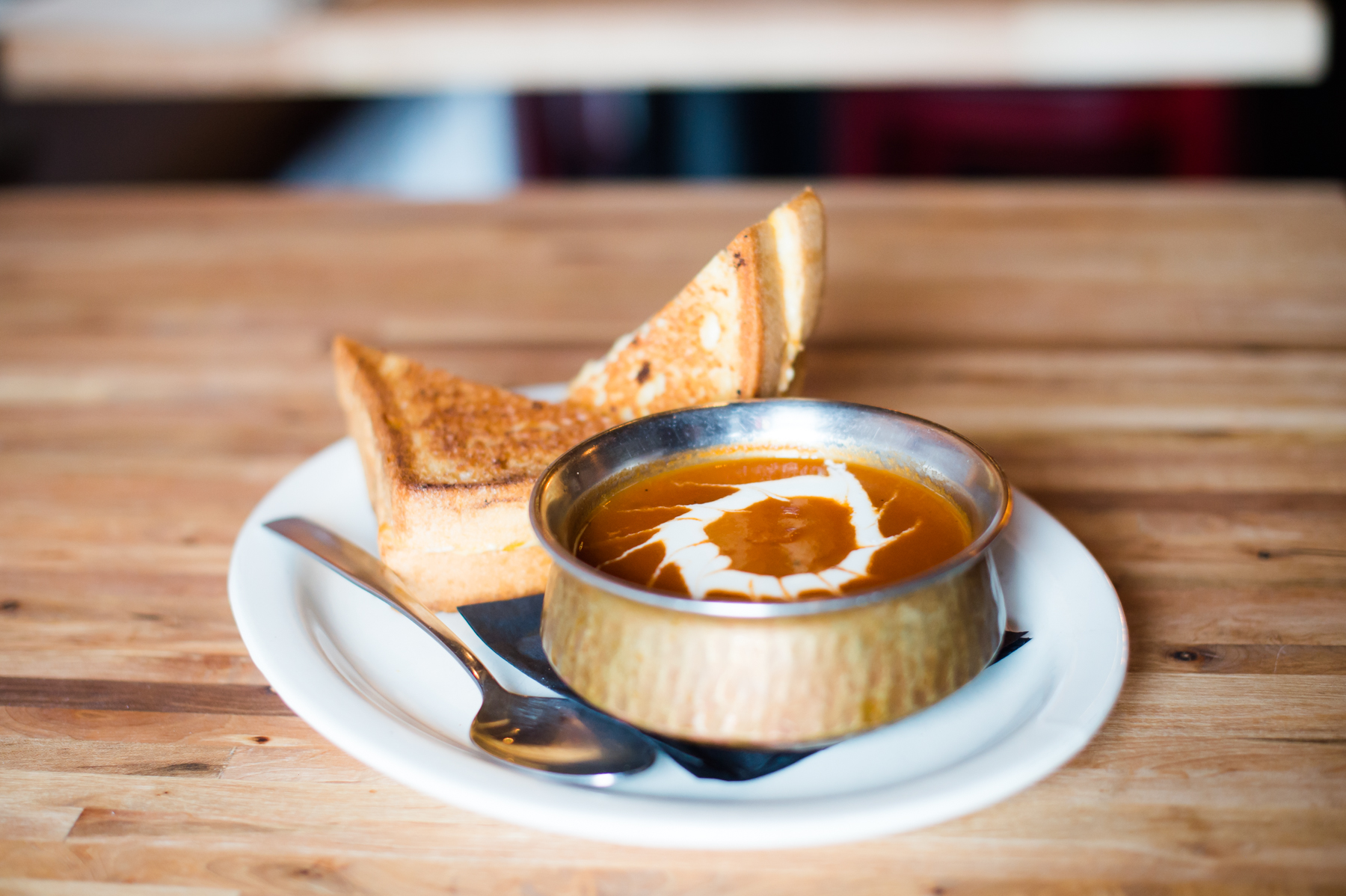 A bowl of grilled cheese and tomato soup 