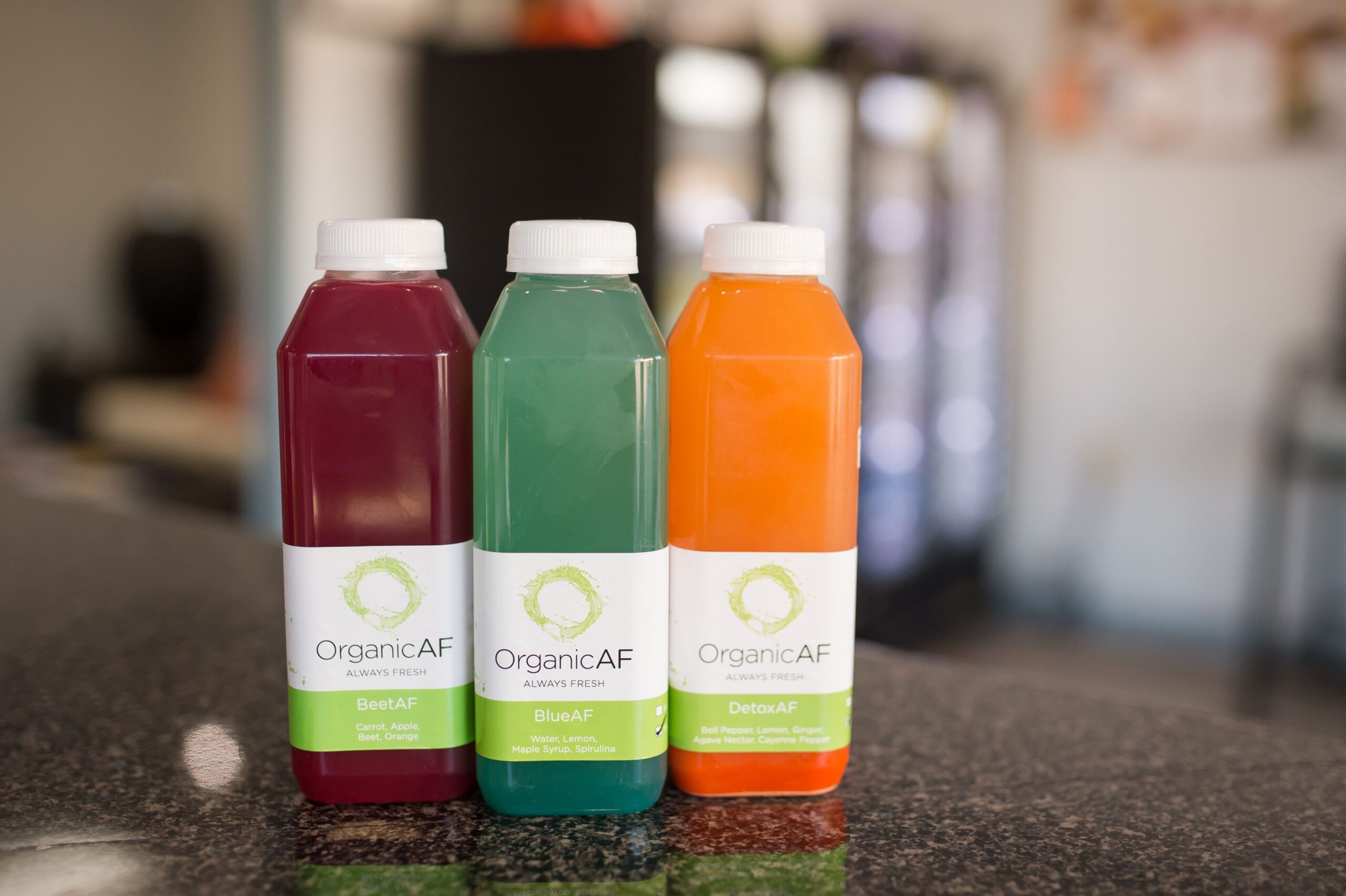 Three bottles of pressed juice from OrganicAF in High Point sit on a counter.