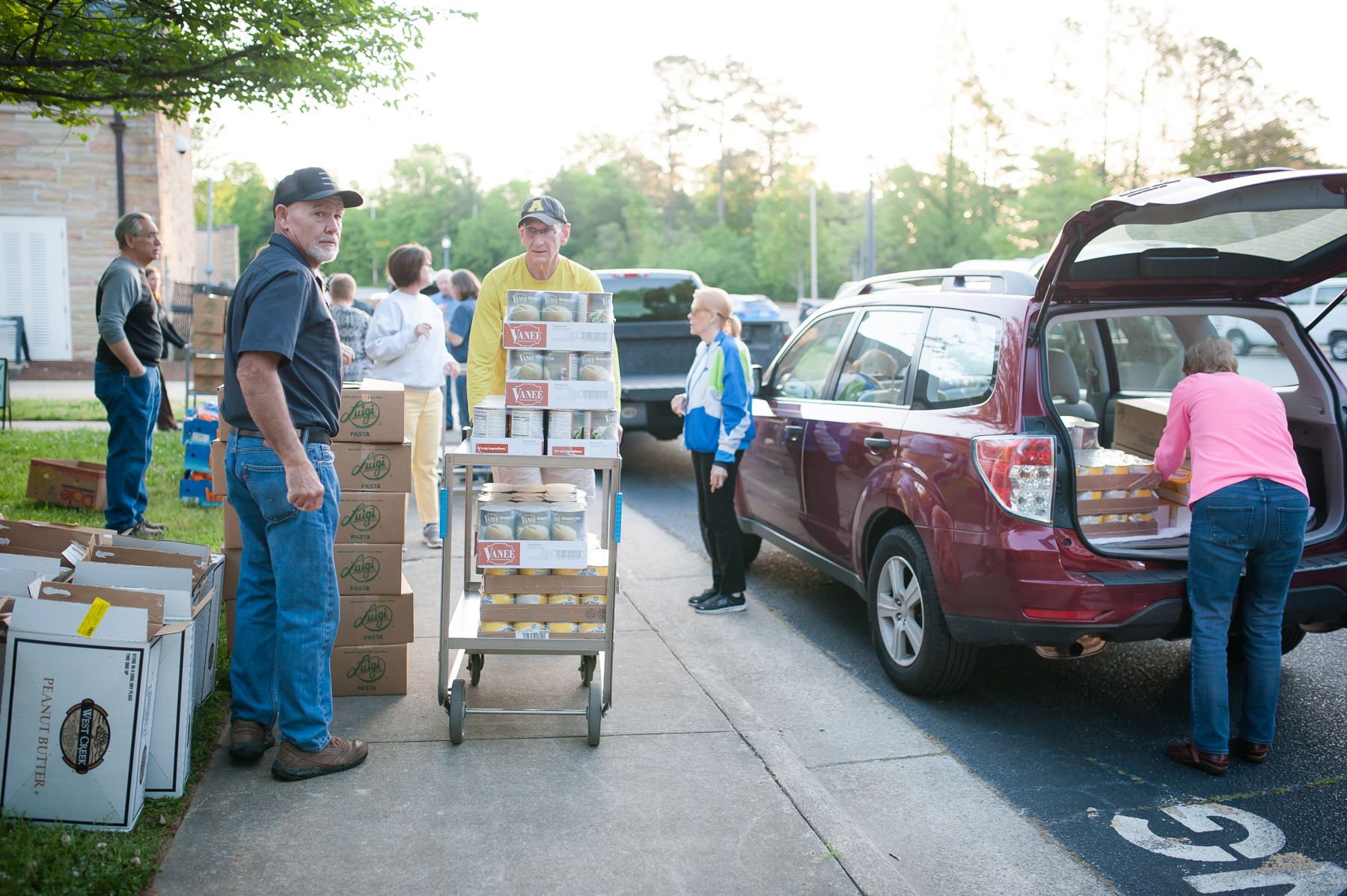 A man stands on the sidewalk with packaged food at Feeding Lisa's Kids in High Point, NC.