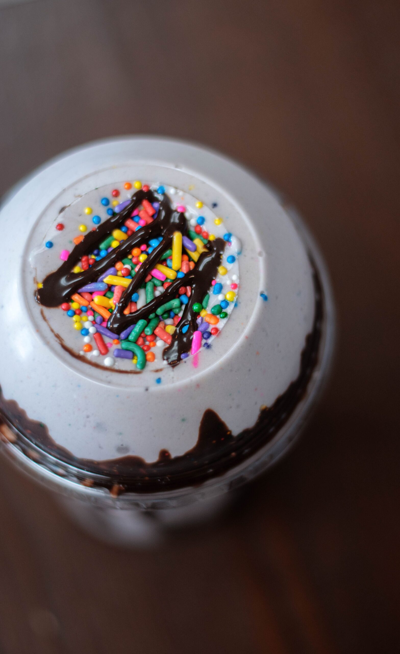 The top of a Nutrition on Main protein shake with High Point, NC, that has sprinkles and chocolate syrup.