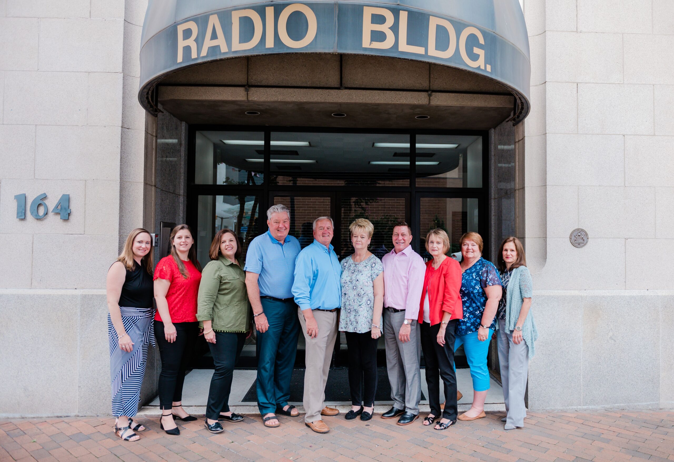 The High Point Market Authority team stand in front of the old Radio Building in High Point, NC.
