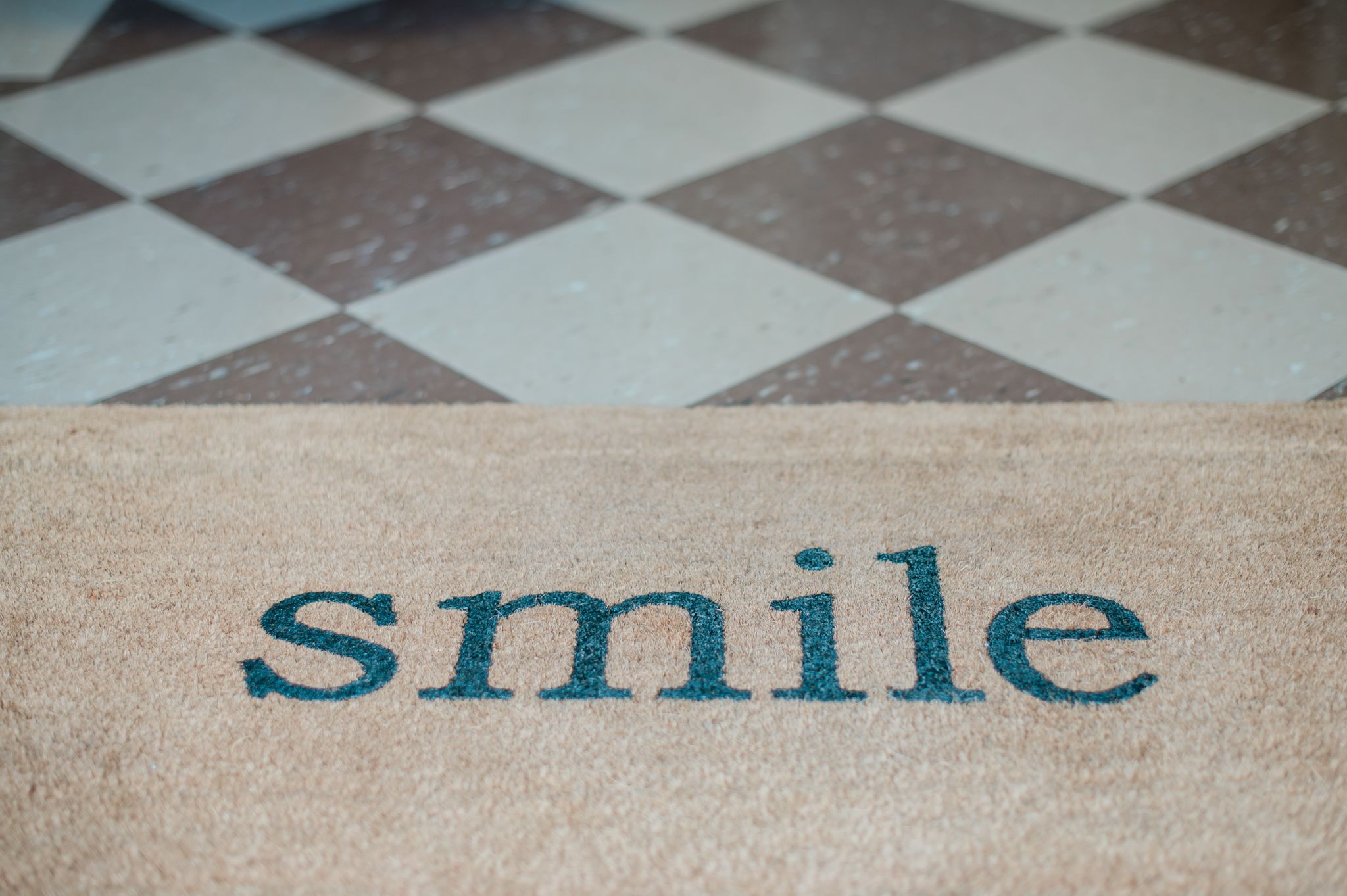 A floor mat that says "Smile" in the doorway of Nunn Denistry in High Point, NC.