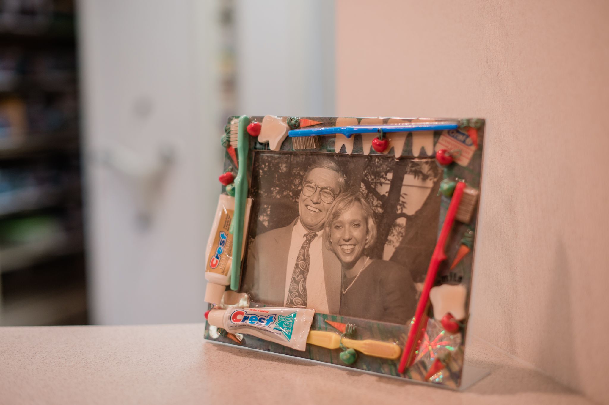 A photo in a frame with toothbrushes and toothpaste of Dr. Lee Bass Nunn with her father, Dr. Bass.