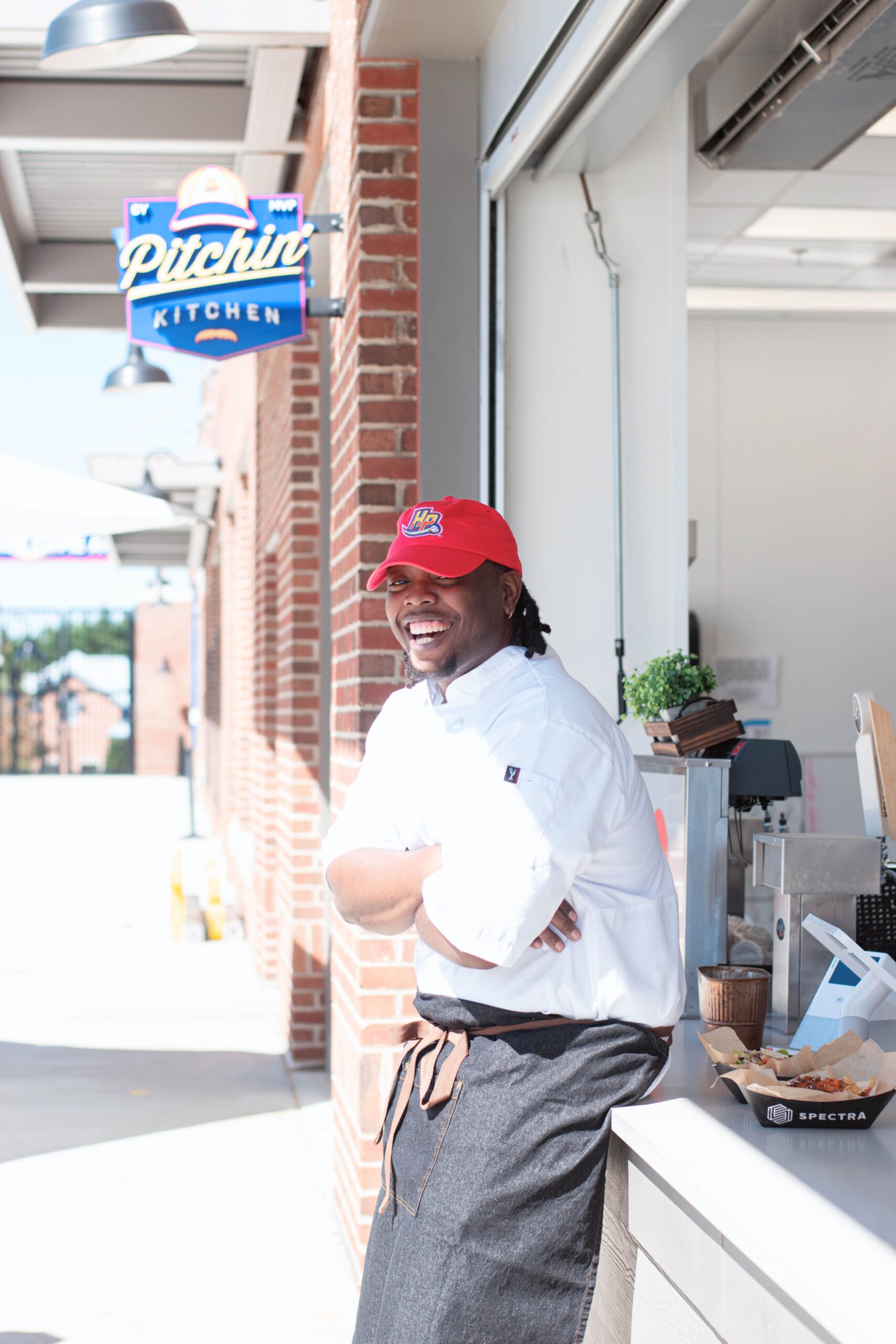 Miquel Phillips laughs leaning against the counter at the Pitchin' Kitchen at the High Point Rocker's stadium in High Point, NC.