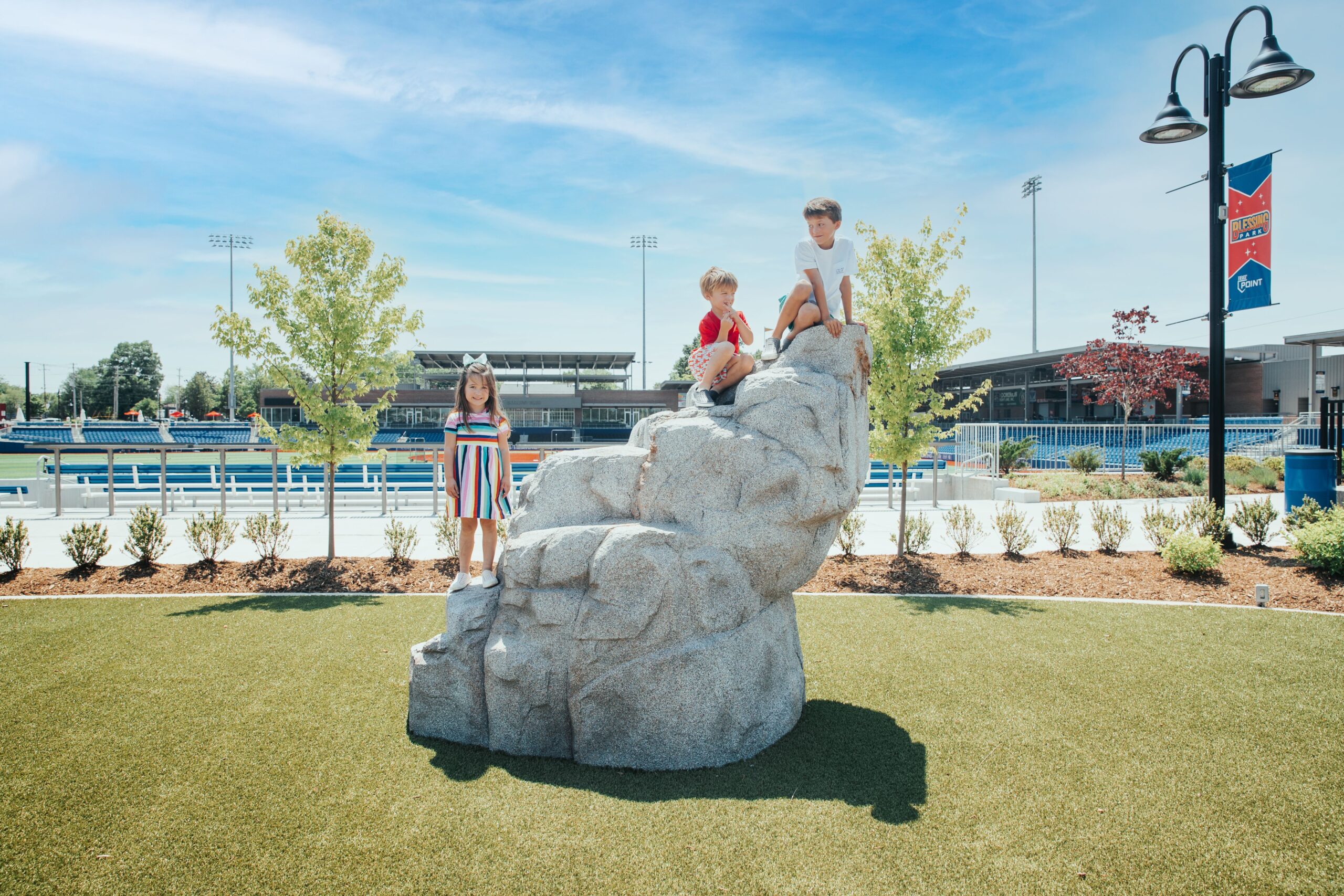 Kids climb on the boulder at Blessing Park inside the High Point Rockers stadium in High Point, NC.