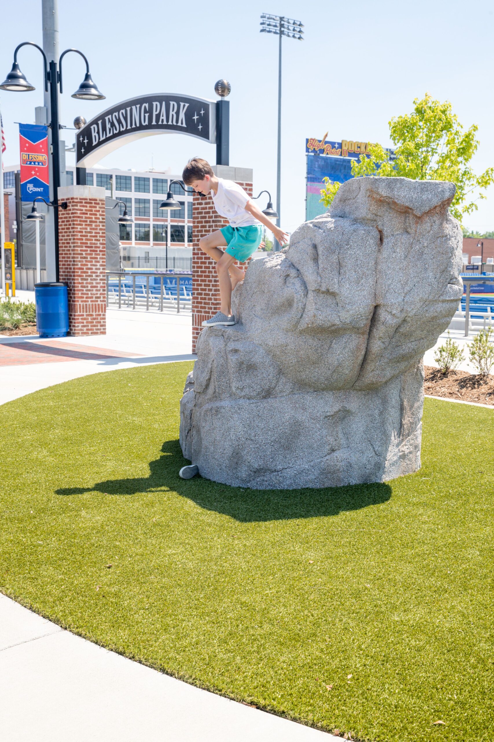 A boy climbs on the boulder at Blessing Park in High Point, NC at the High Point Rockers and Truist Point Stadium. 