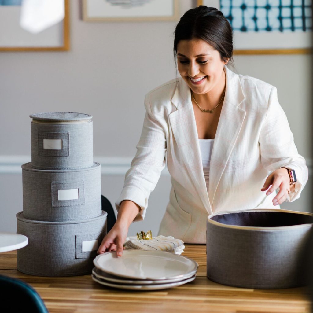 Shirley Simauchi, owner of Homeycasa, organizes plates into a container in High Point, NC.