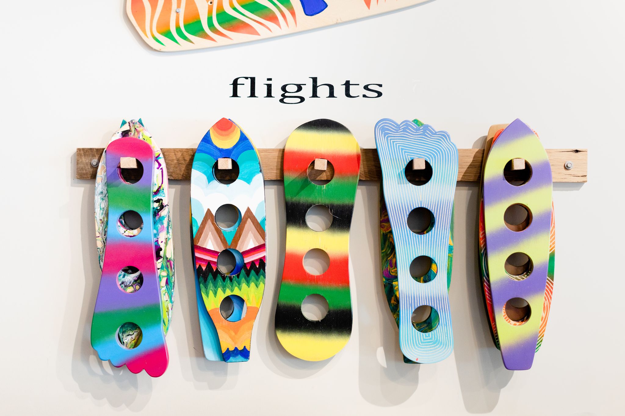Flight holders shaped like surf boards and skate boards at Goofy Foot Taproom in High Point, NC.
