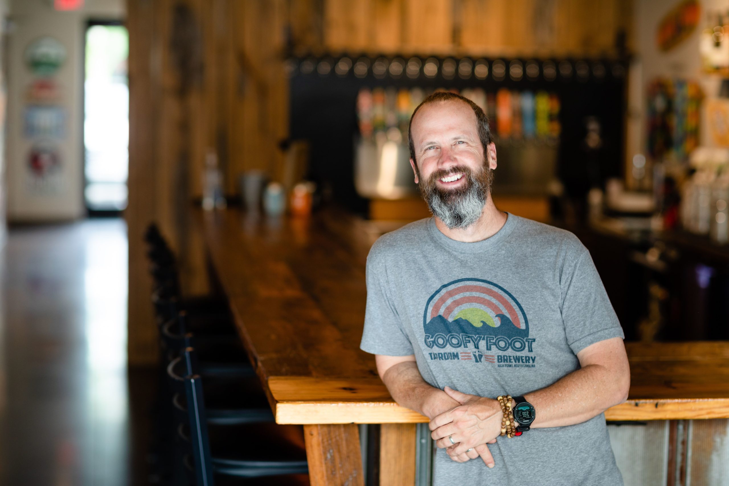 Jeff Thompson, owner of Goofyfoot Taproom and Brewery leans on the counter of his bar.