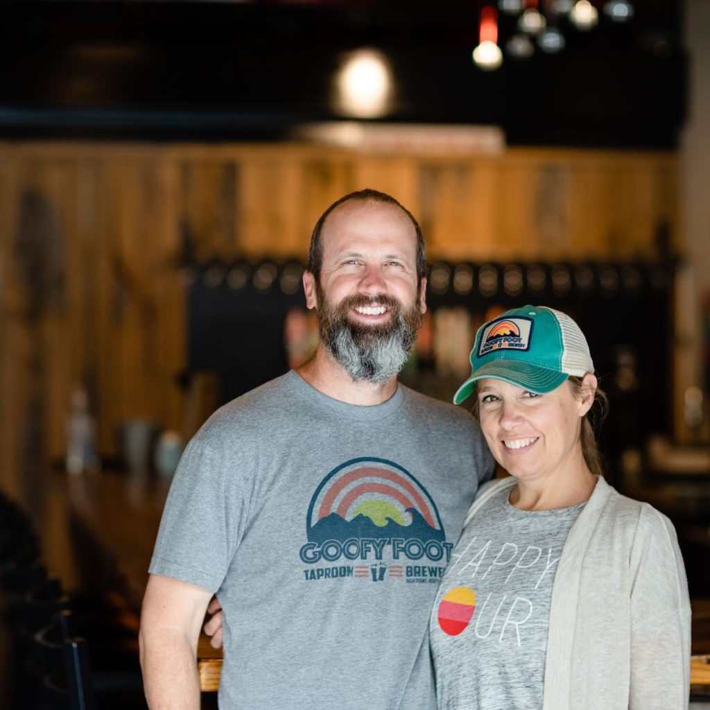 Tiffany and Jeff Thompson smiling in Goofy Foot Taproom in High Point, NC