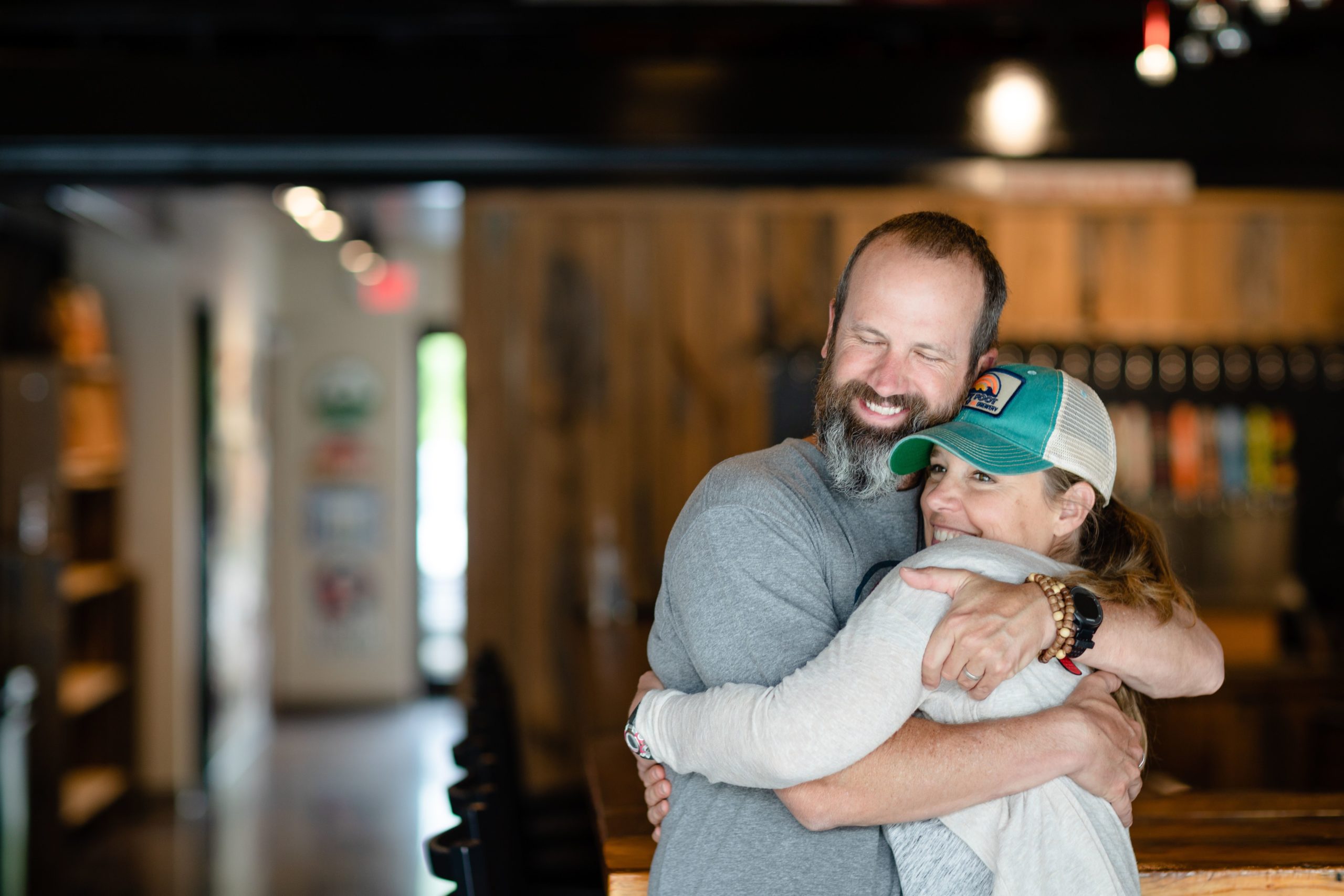 Jeff and Tiffany Thompson, owners of Goofyfoot Taproom and Brewery in High Point, NC hug.