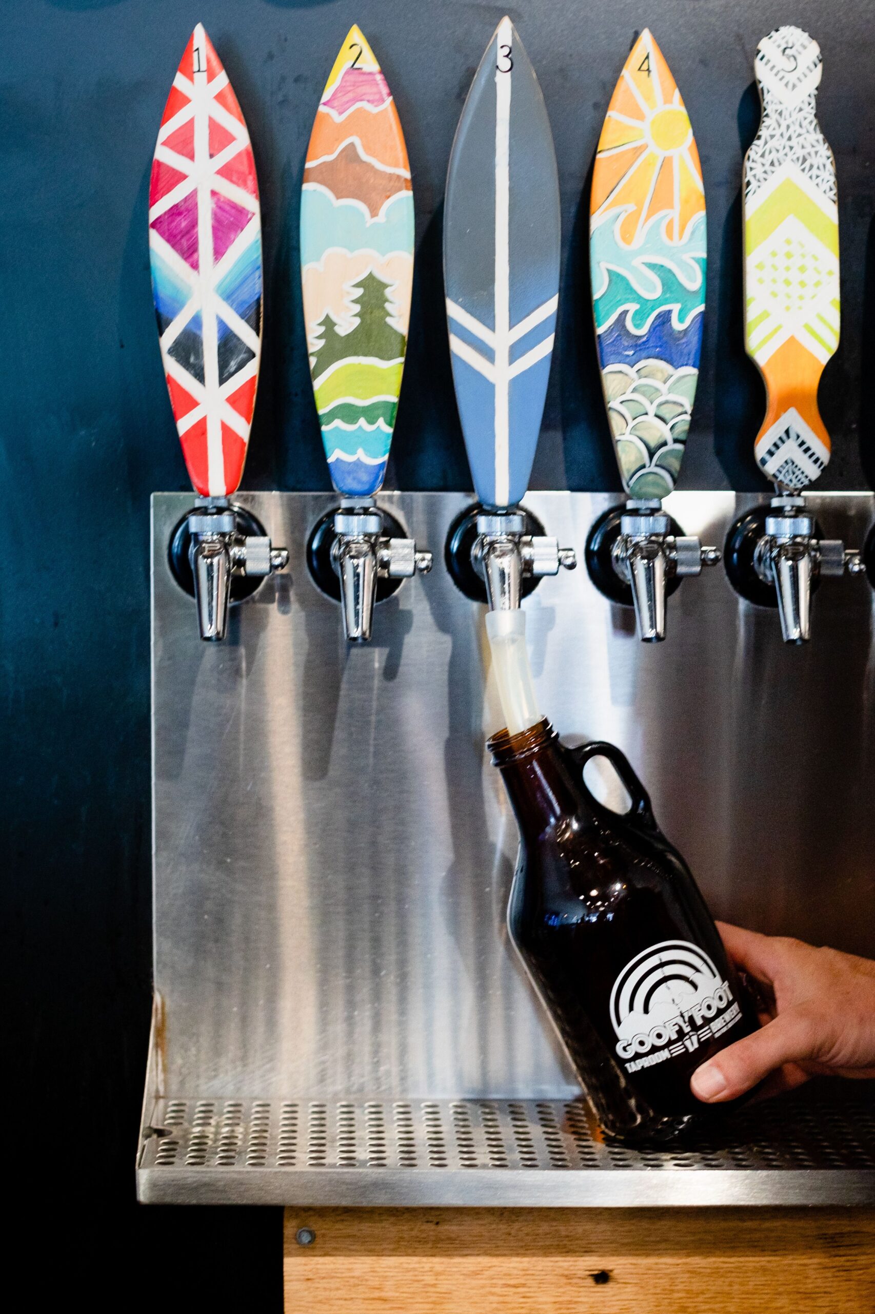 Someone fills up a growler from the beer taps at High Point brewery, Goofy Foot Taproom and Brewery.