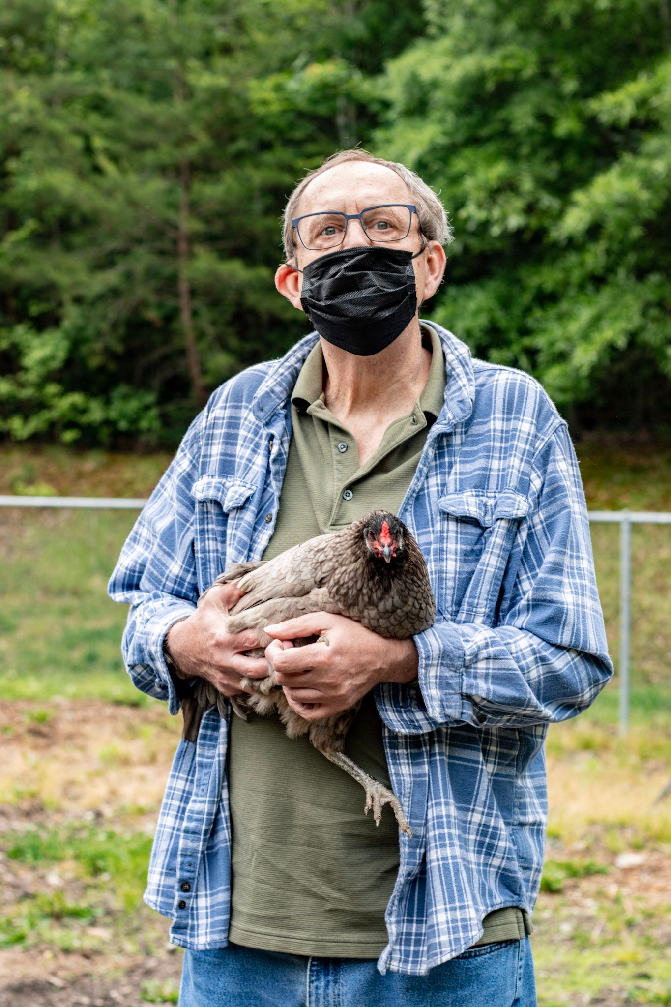 Wild and Free participant, Tim, holds one of the chickens from the program's chicken coop.