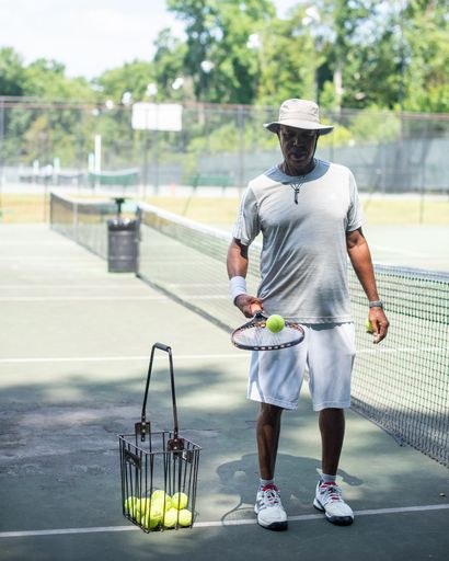 Junius Chapman bouncing tennis ball on tennis court in High Point, NC