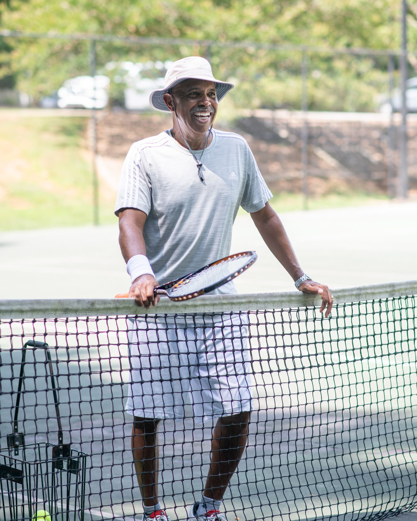 Junius Chatman, Tennis Director at the Oak Hollow Tennis Center in High Point, NC, laughs at the camera. 
