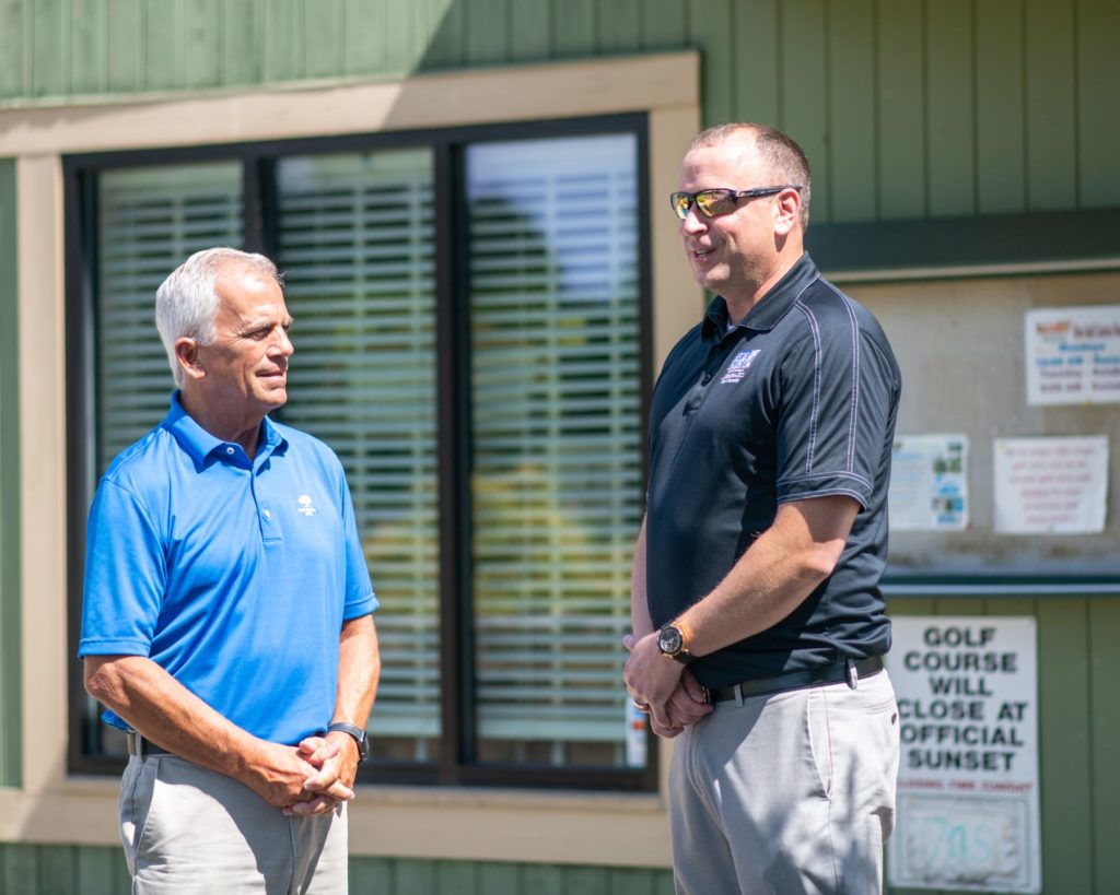 Lee Tillery stands chatting with Steve High, PGA Golf Administrator at Oak Hollow Golf Course.