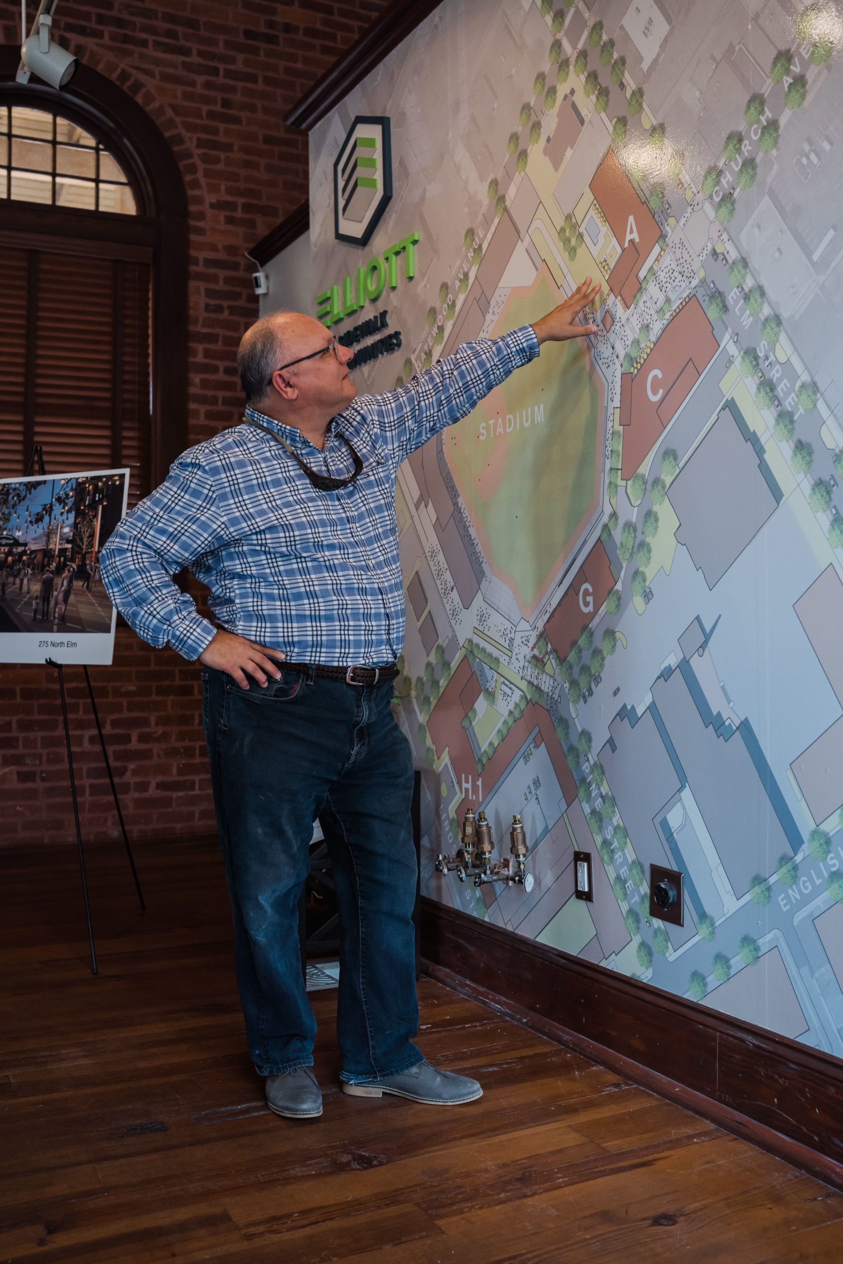 Tim Elliot, Founder of Elliot Sidewalk Communities points to a map of The Outfields in High Point, NC.