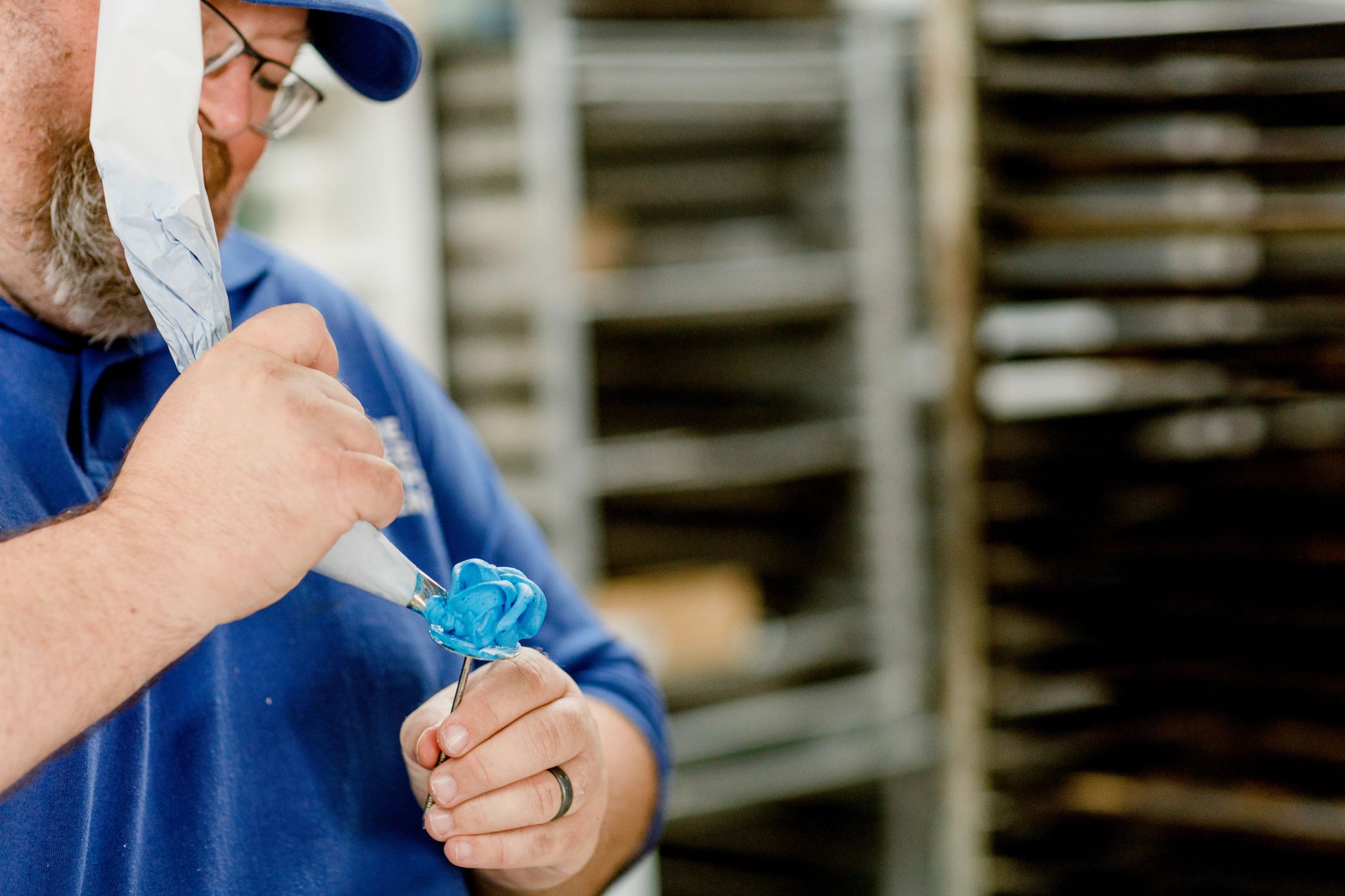 Ken Cagle Jr. pipes icing onto a cupcake at Sweet Shoppe Bakery.