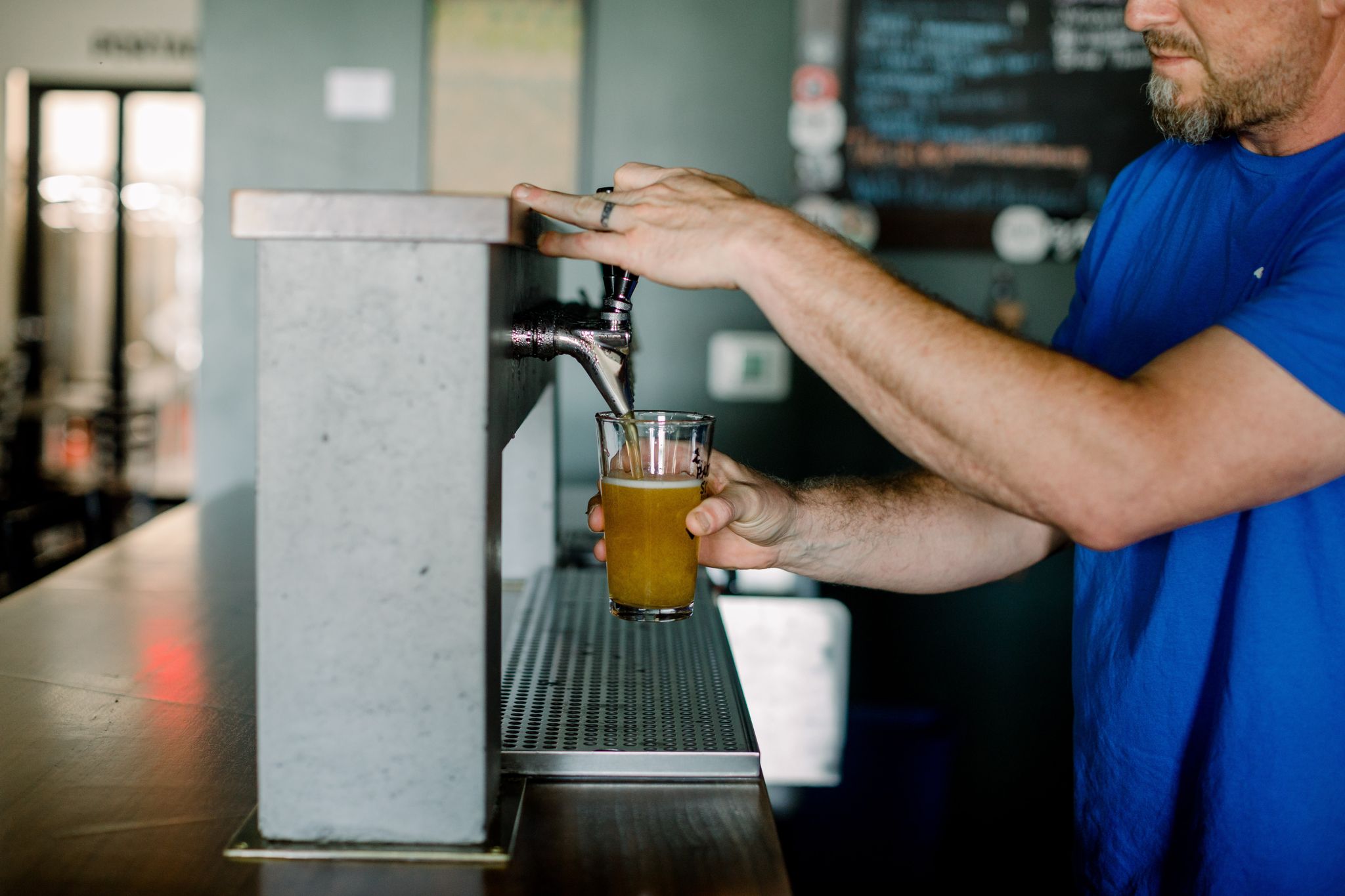 Dave Nissen pours a beer from the taps at Paddled South Brewing Co. in High Point, NC.