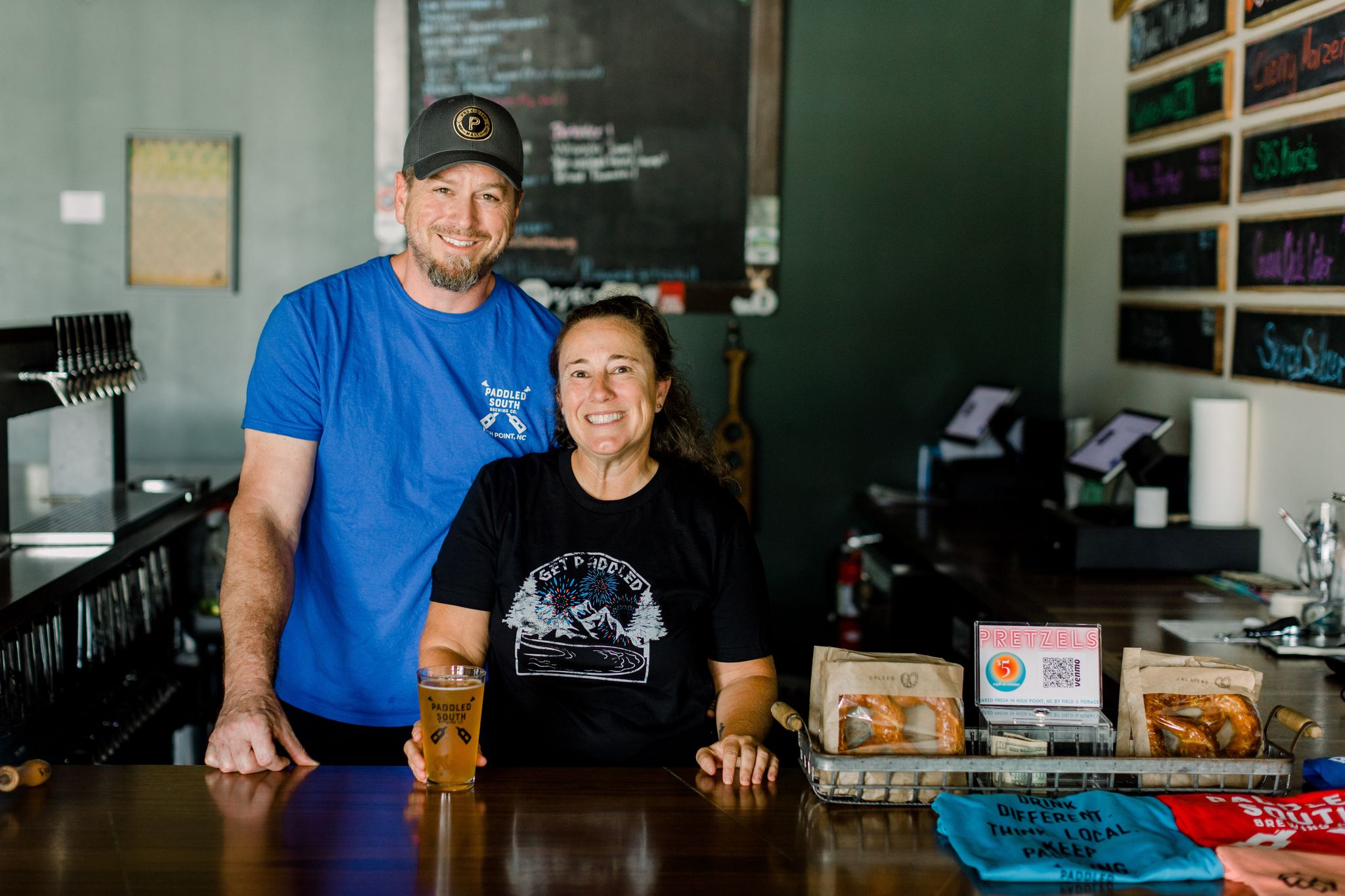 Dave and Amy Nissen, owners of Paddled South Brewing Co., in High Point, NC stand at the bar.