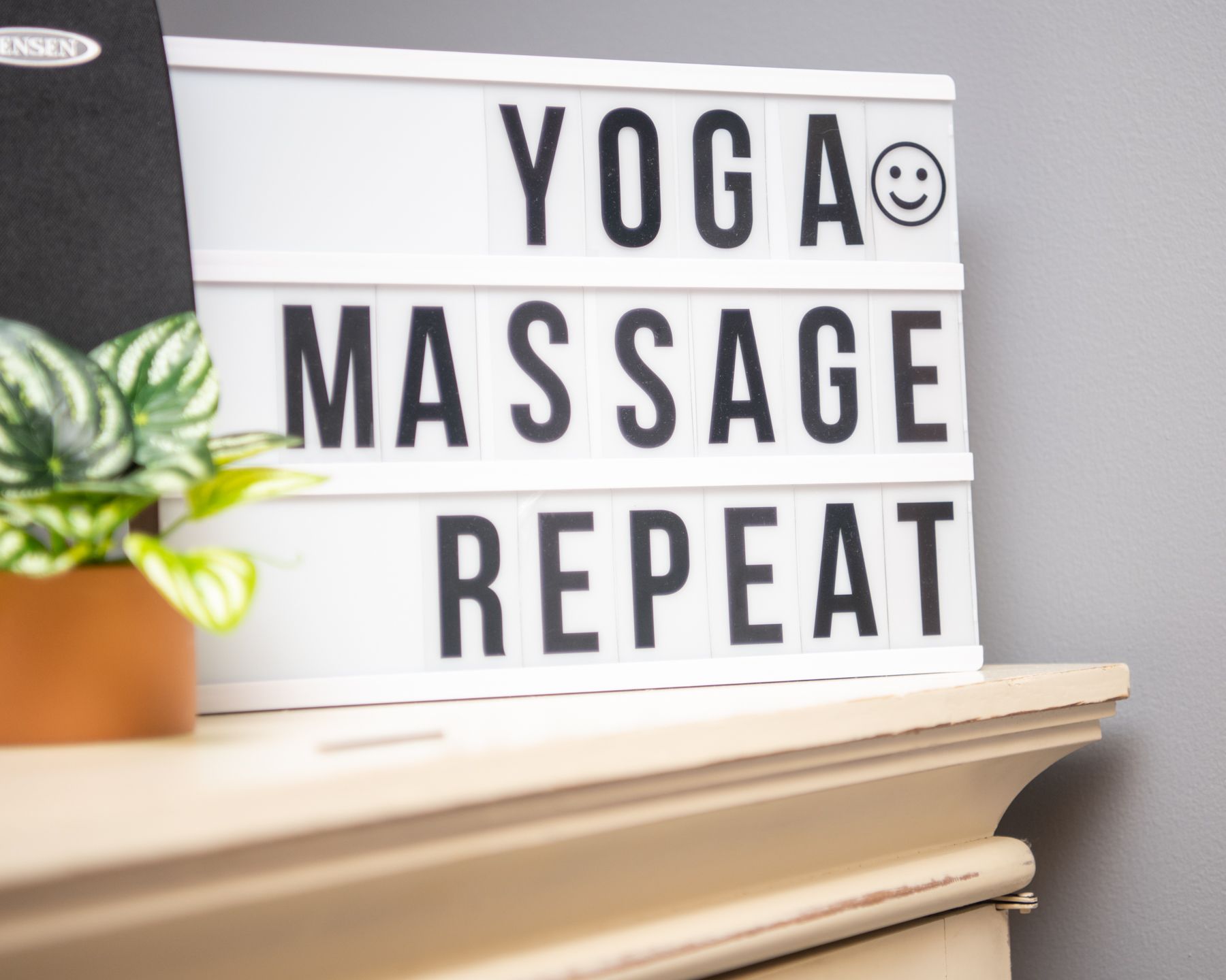 A sign that says "Yoga, massage, repeat," sits on a table at Willow Wellness Center in High Point, NC.