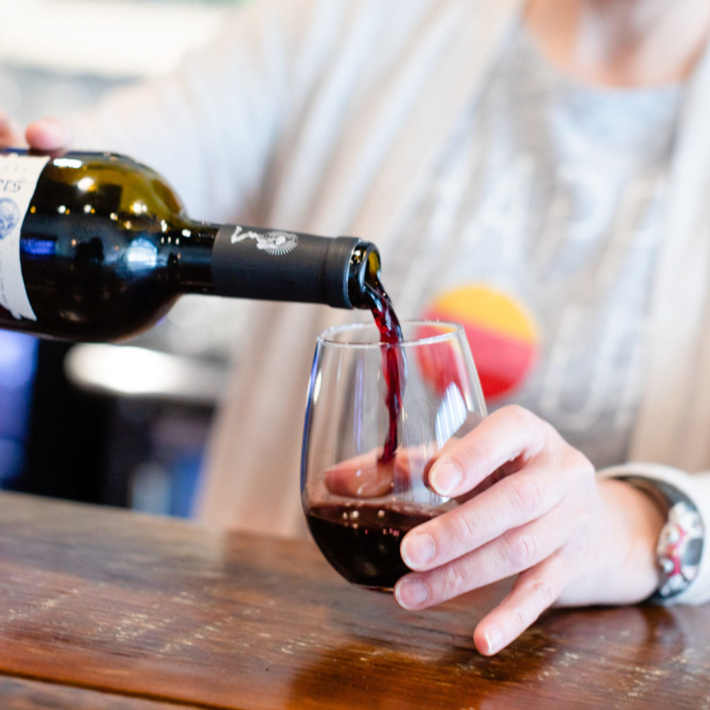 Feature Image of A woman pours a glass of wine for herself