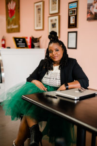 Founder of The Buy Black Guide Temoura Jeffries sits in a coffee shop in