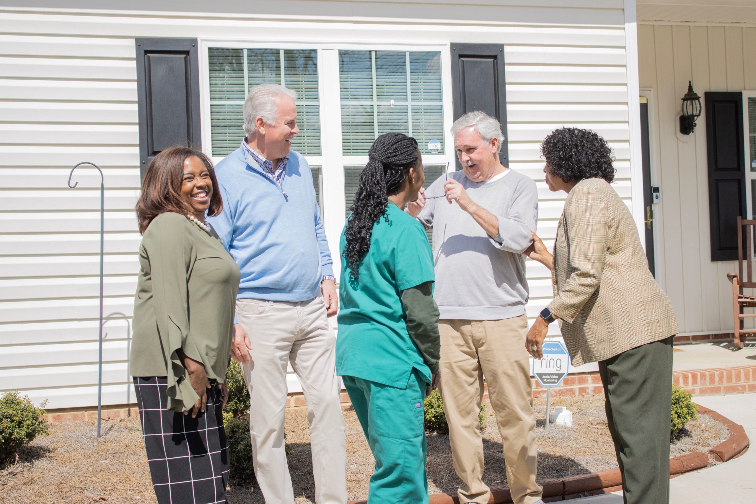 A group of professionals from Pinnacle Financial Partners stands in front of the homes as part of their Affordable Housing Program in High Point, NC.